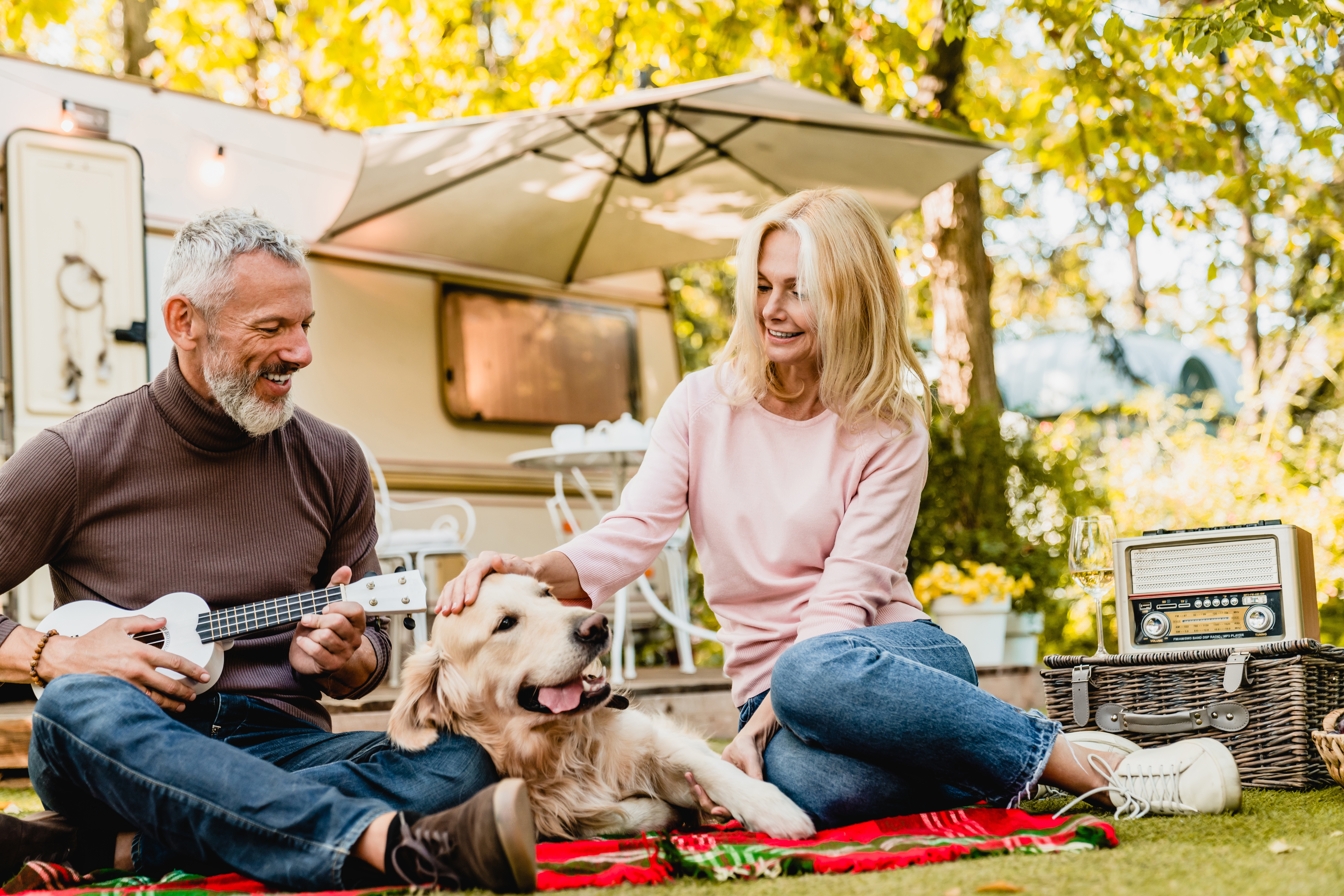 Joyful,Aged,Couple,With,Dog,Relaxing,On,The,Blanket,Near