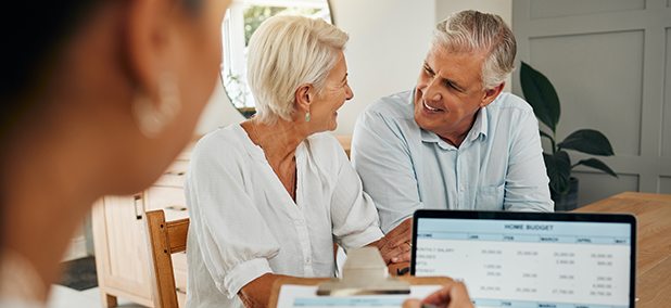 Senior couple reviewing their assets and debts with a financial advisor during a retirement planning meeting.