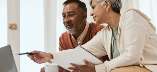 Couple discussing finances and reviewing their retirement plan during an annual financial check-in.