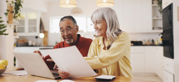 Couple reviewing beneficiary and retirement planning documents together at home.